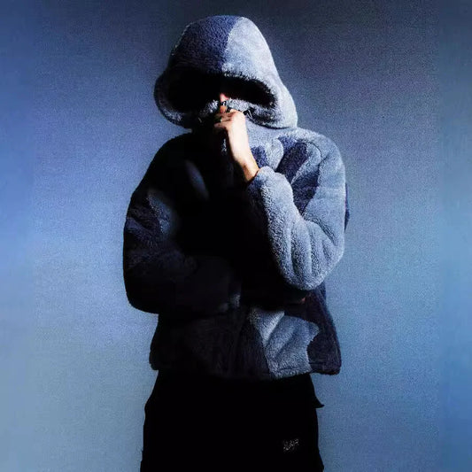 Person wearing a blue fleece jacket with a hood against a gradient blue background