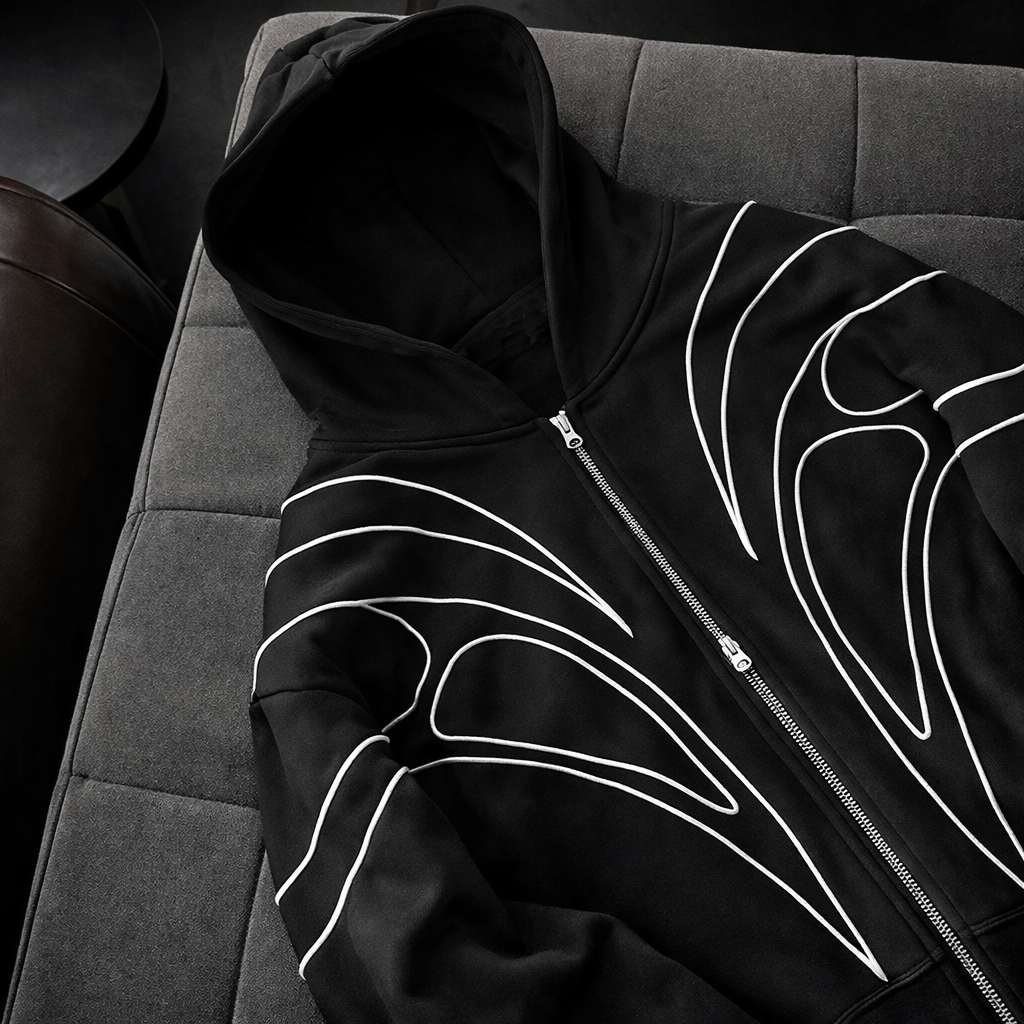 Black hoodie with white designs on a gray surface