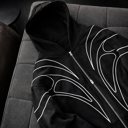 Black hoodie with white designs on a gray surface