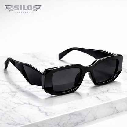Black sunglasses on a marble surface with 'Silo Apparel' branding.