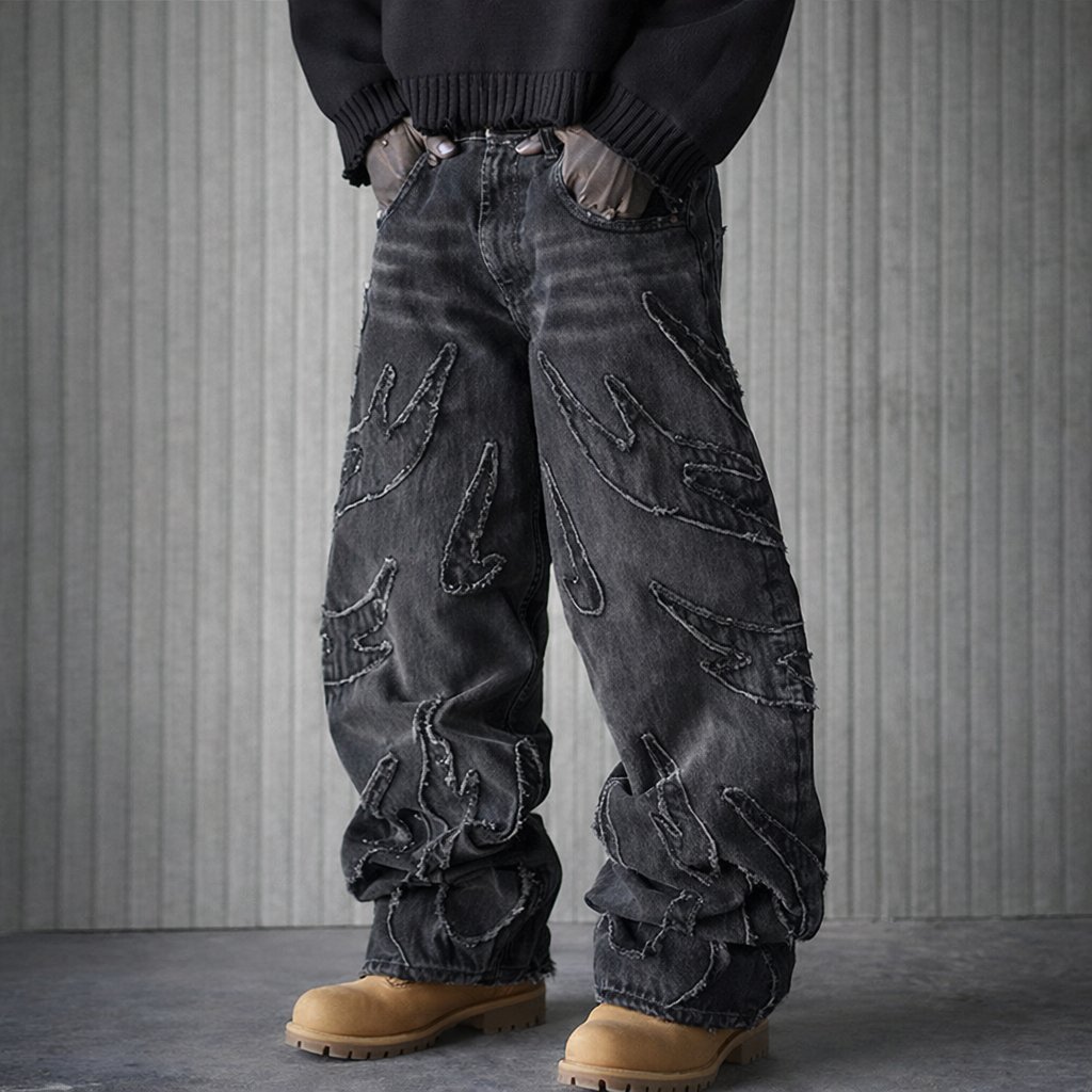 Person wearing dark distressed jeans and brown boots against a gray background