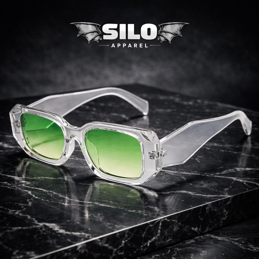 Clear frame sunglasses with green lenses on a dark marble surface, branded 'Silo Apparel'.